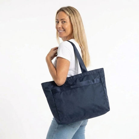 Vrouw draagt de Zeeksack Packable Travel Tote in Navy Blue over haar schouder