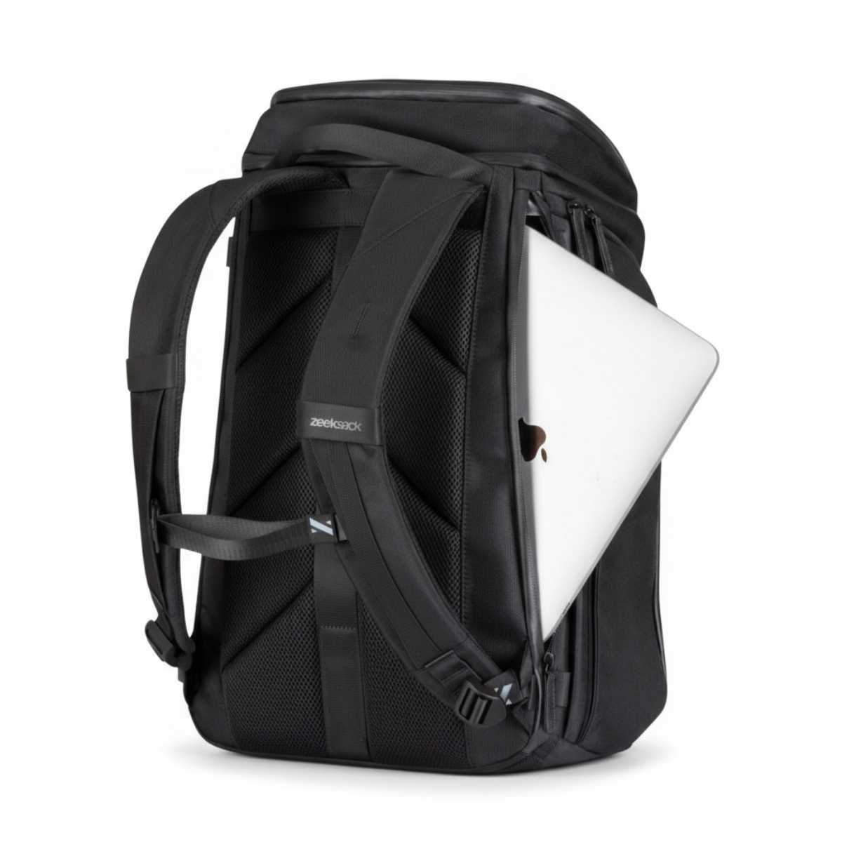 Zwarte rugzak met een zilverkleurige laptop gedeeltelijk in het zijvak geschoven.