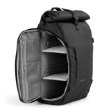 Een stijlvolle zwarte rolltop-rugzak, vanaf de zijkant geopend en leeg vanbinnen.